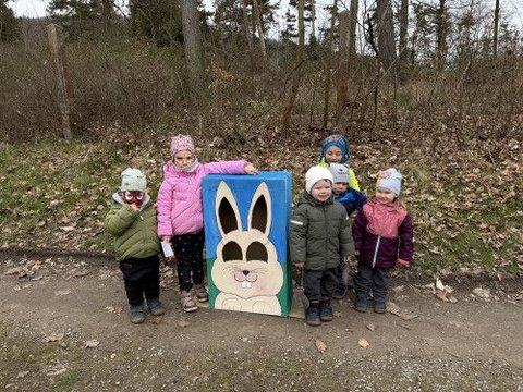 Skupina dětí stojí u terče s velikonočním zajíčkem.