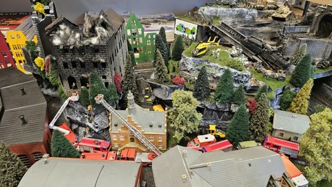 Detail modelového města s budovami, stromy a zásahovými vozidly