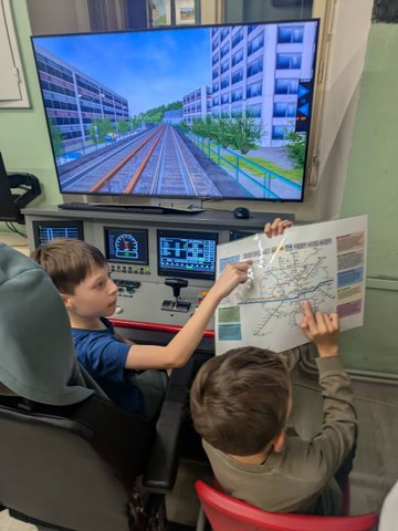 Účastníci železničního kroužku při práci se simulátory a železniční technikou