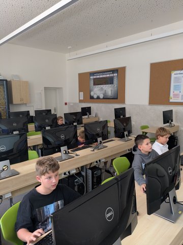 Děti pracují u počítačů v učebně