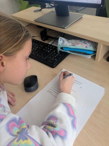 Dítě vyplňuje pracovní list u počítače