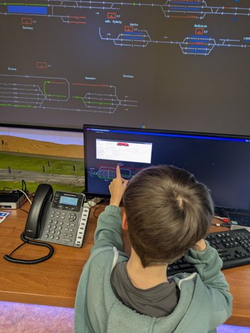 Účastníci železničního kroužku při práci se simulátory a železniční technikou